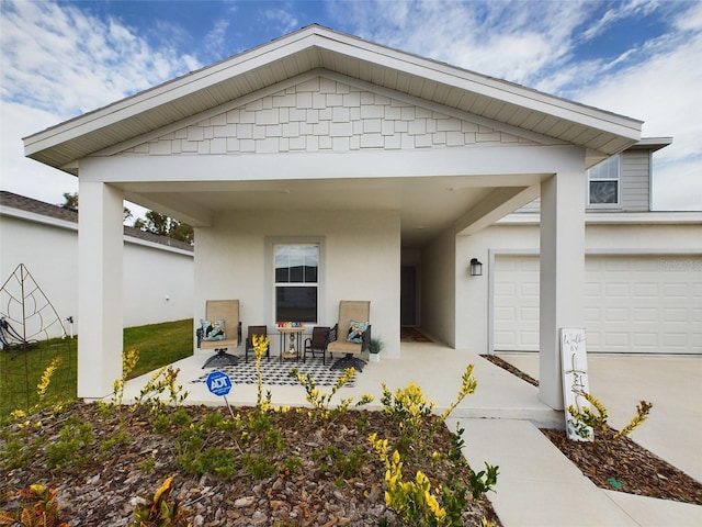 exterior space featuring a garage, driveway, and stucco siding