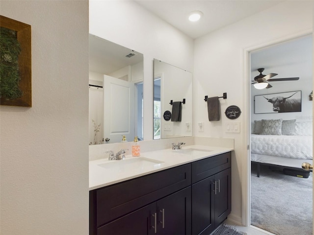 ensuite bathroom featuring double vanity, ensuite bath, a ceiling fan, and a sink