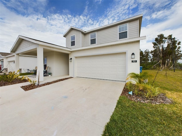 traditional home featuring a front yard, concrete driveway, and stucco siding