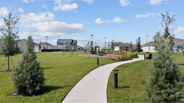 view of community featuring a residential view, a lawn, and playground community