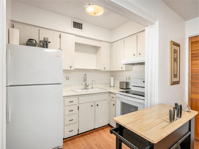 kitchen with tasteful backsplash, white appliances, sink, and light wood-type flooring