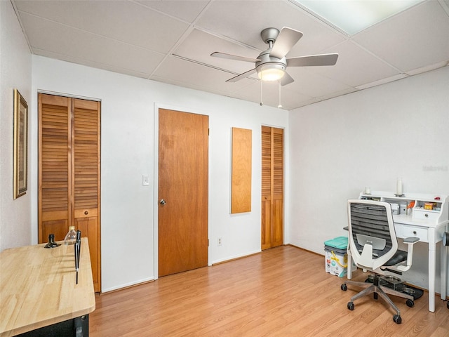 home office with hardwood / wood-style floors, a paneled ceiling, and ceiling fan