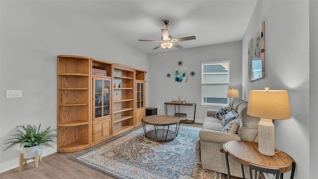 living area featuring wood-type flooring and ceiling fan