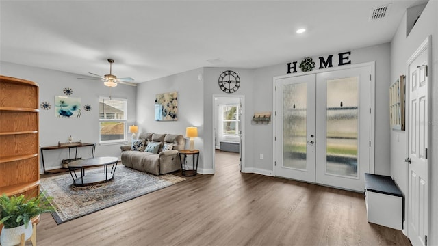 living room with hardwood / wood-style floors, ceiling fan, and french doors