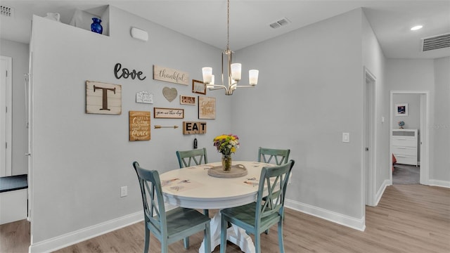 dining area with a notable chandelier and light wood-type flooring