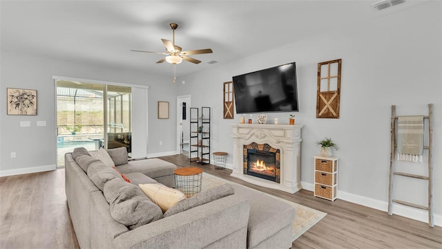 living room with wood-type flooring and ceiling fan