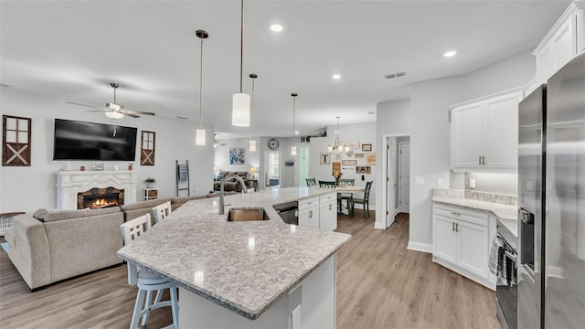 kitchen with pendant lighting, sink, a large island, and white cabinets