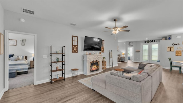 living room with light hardwood / wood-style floors, french doors, and ceiling fan