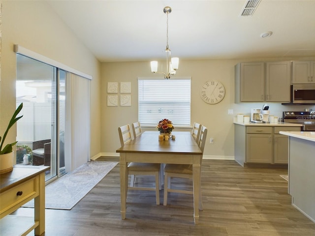 dining area with hardwood / wood-style flooring and an inviting chandelier