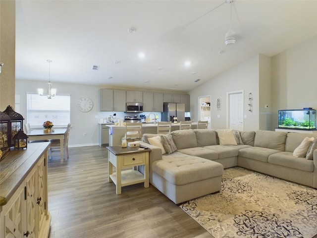 living room with vaulted ceiling, sink, and light hardwood / wood-style floors