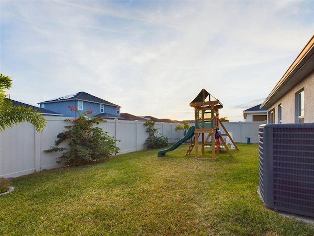 view of play area with central AC and a lawn