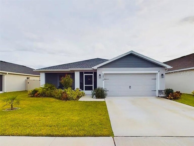 single story home with a garage and a front lawn