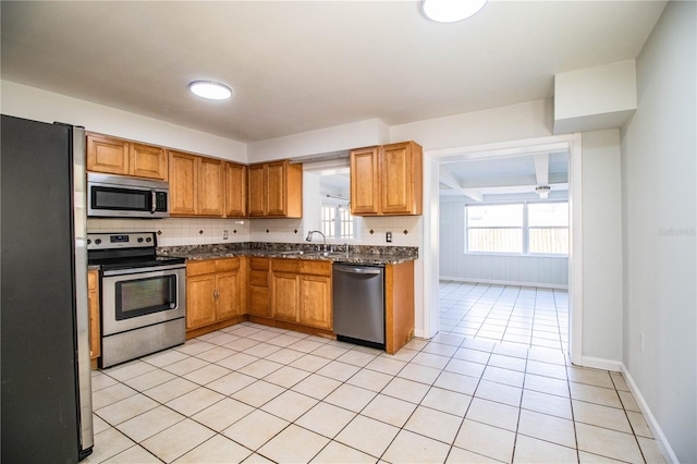 kitchen with decorative backsplash, plenty of natural light, stainless steel appliances, and light tile patterned flooring