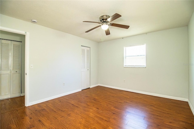 unfurnished bedroom featuring dark wood-type flooring and ceiling fan