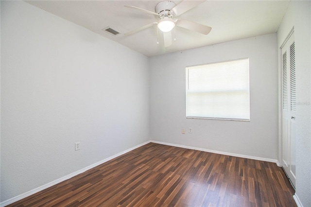 empty room with dark wood-type flooring and ceiling fan