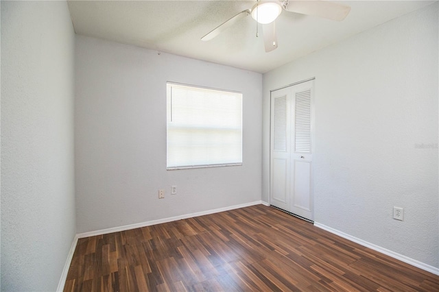 empty room with dark hardwood / wood-style floors and ceiling fan