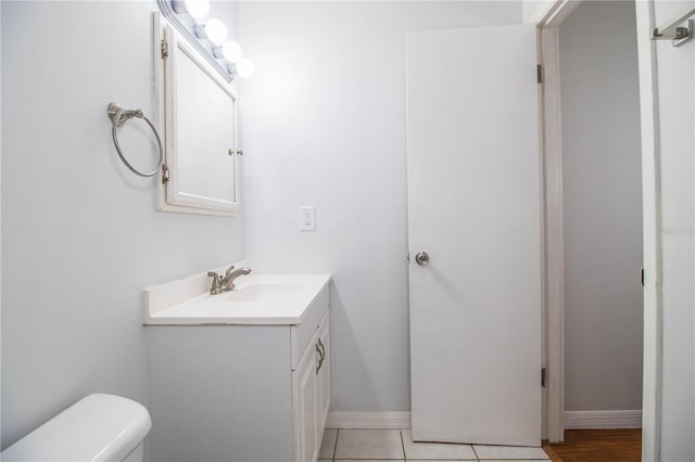 bathroom featuring vanity, tile patterned flooring, and toilet