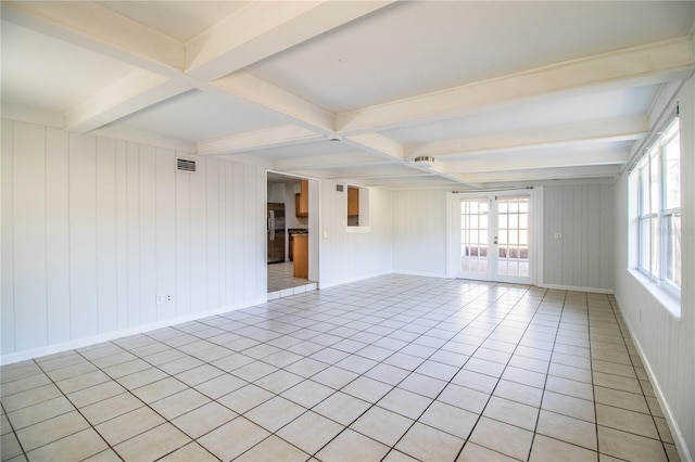 unfurnished room with light tile patterned floors, beam ceiling, and french doors