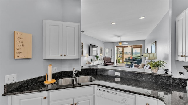 kitchen featuring sink, dark stone countertops, dishwasher, ceiling fan, and white cabinets