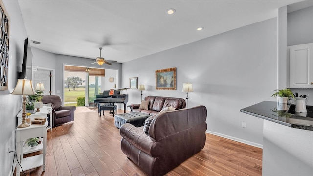 living room featuring ceiling fan and light hardwood / wood-style floors