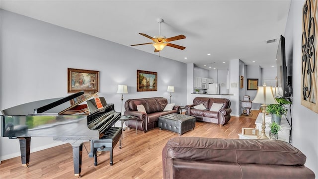 living room with ceiling fan and light hardwood / wood-style flooring