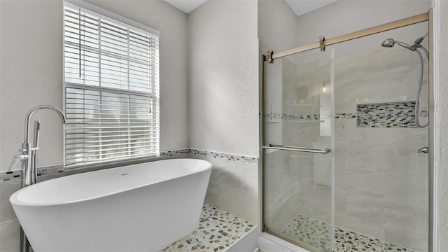 bathroom featuring tile walls and shower with separate bathtub