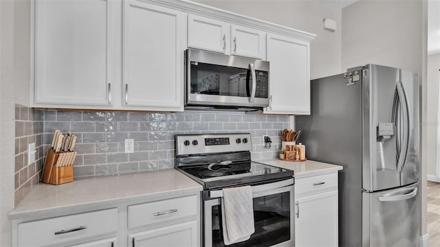 kitchen featuring tasteful backsplash, light stone counters, white cabinets, and appliances with stainless steel finishes