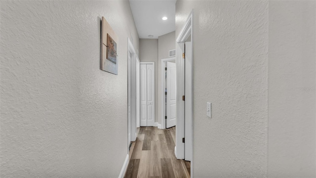 corridor with light hardwood / wood-style floors