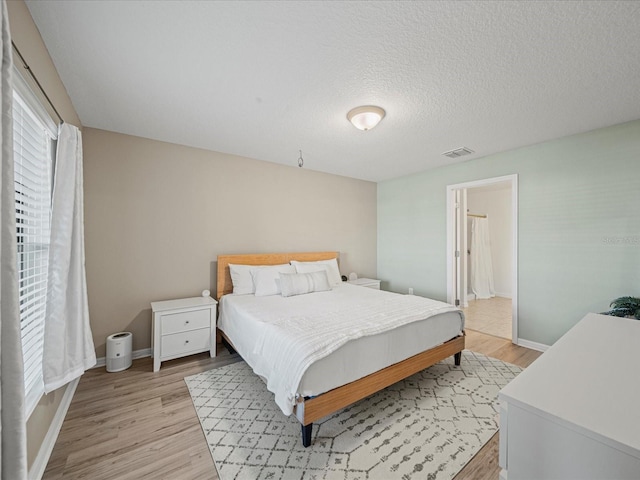 bedroom featuring a textured ceiling and light wood-type flooring