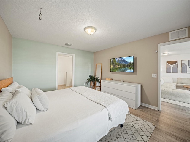 bedroom featuring a textured ceiling and light wood-type flooring