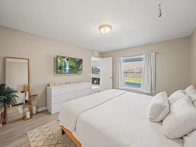 bedroom featuring a textured ceiling and light wood-type flooring