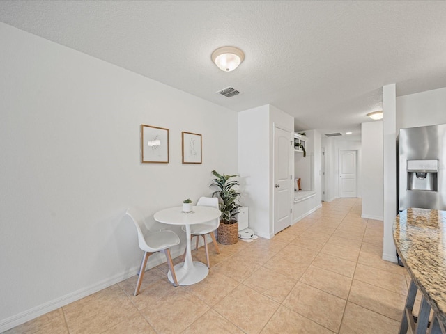 tiled dining room with a textured ceiling