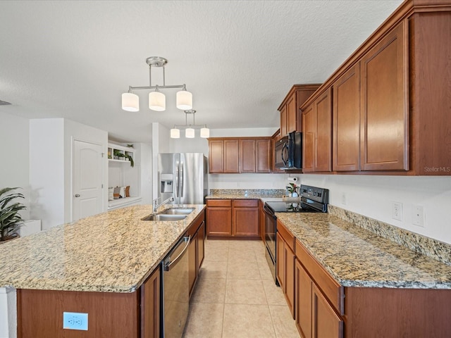 kitchen featuring sink, hanging light fixtures, black appliances, light stone countertops, and a center island with sink