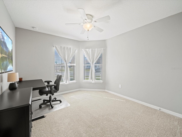 office space with ceiling fan, light colored carpet, and a textured ceiling