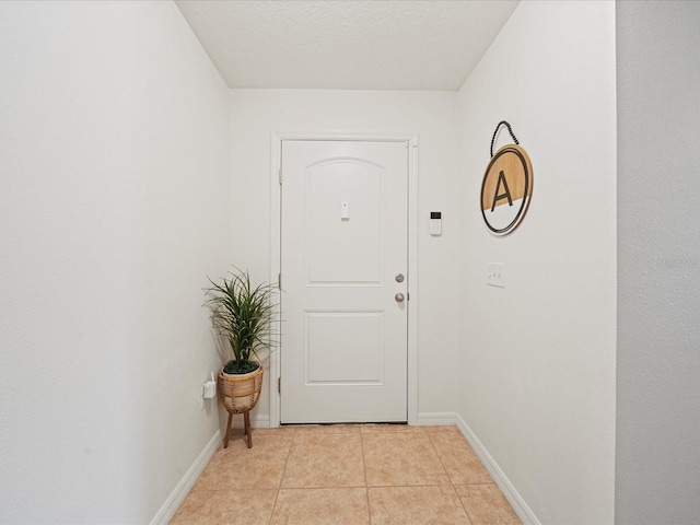 doorway to outside with light tile patterned flooring and a textured ceiling