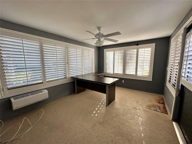 unfurnished office featuring a wall mounted AC and ceiling fan