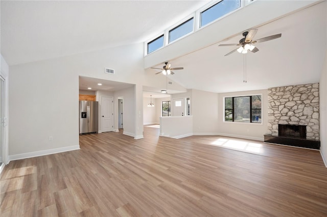 unfurnished living room with ceiling fan, a fireplace, and light hardwood / wood-style floors