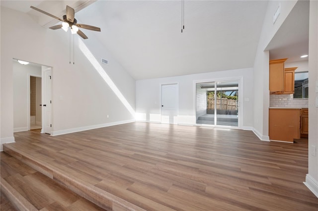 unfurnished living room with ceiling fan, high vaulted ceiling, and light hardwood / wood-style flooring