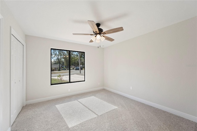 unfurnished bedroom featuring ceiling fan, light carpet, and a closet