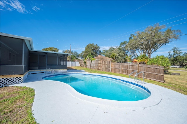 view of pool with a sunroom and a lawn