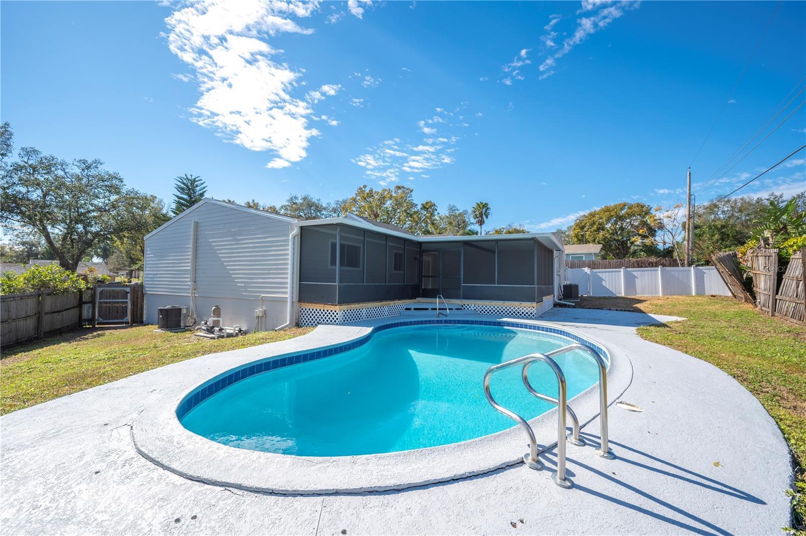 view of swimming pool featuring a sunroom, cooling unit, and a lawn