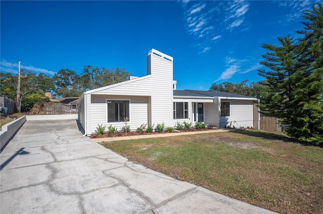 ranch-style home featuring a front lawn