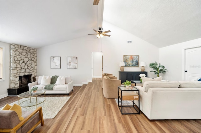 living area with ceiling fan, light wood-type flooring, lofted ceiling, and a fireplace