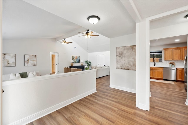 living area with light wood-style flooring, a ceiling fan, and baseboards