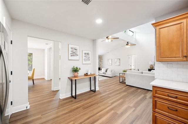 kitchen featuring ceiling fan, light wood finished floors, backsplash, light countertops, and recessed lighting