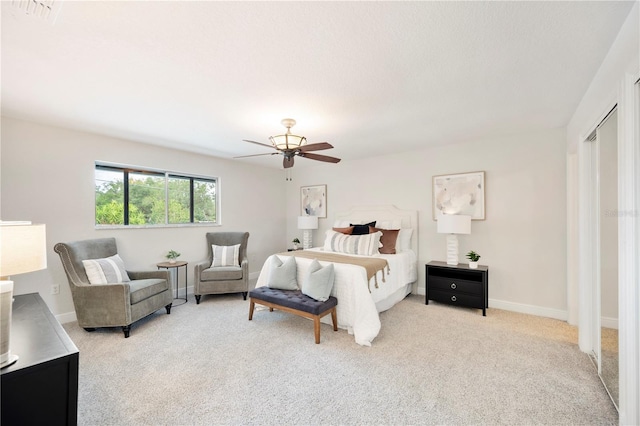 bedroom with light colored carpet, ceiling fan, and baseboards