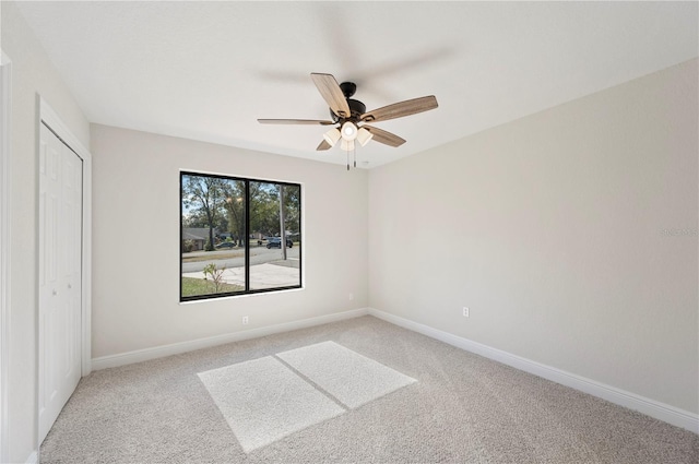 unfurnished bedroom featuring light carpet, baseboards, a closet, and ceiling fan