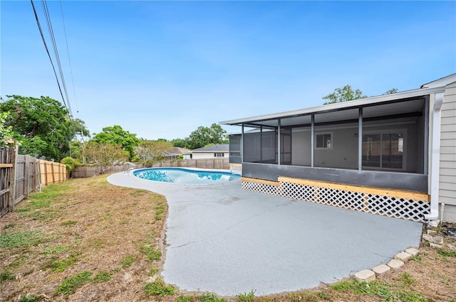 view of swimming pool with a sunroom and a patio area