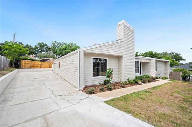mid-century inspired home featuring a chimney and a patio area