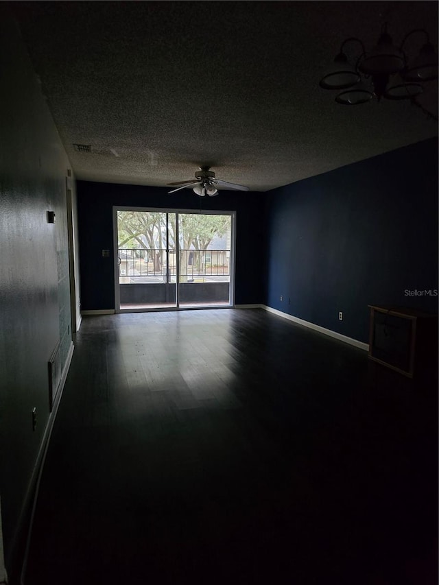 empty room featuring a textured ceiling, wood-type flooring, and ceiling fan